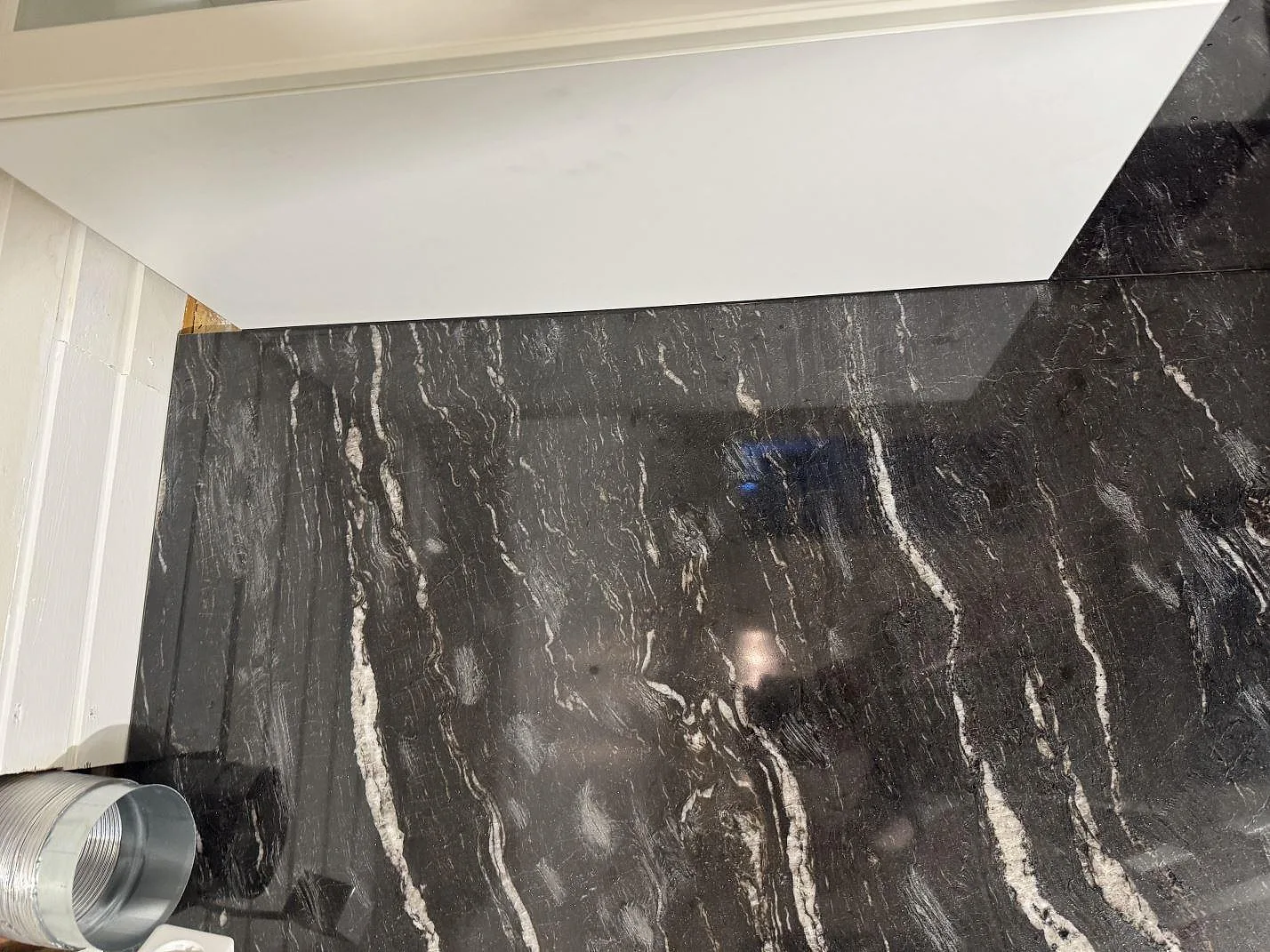 Närbild av polerad Cosmic Black granit som väggbeklädnad med ljusa naturliga ådror i Malmö.