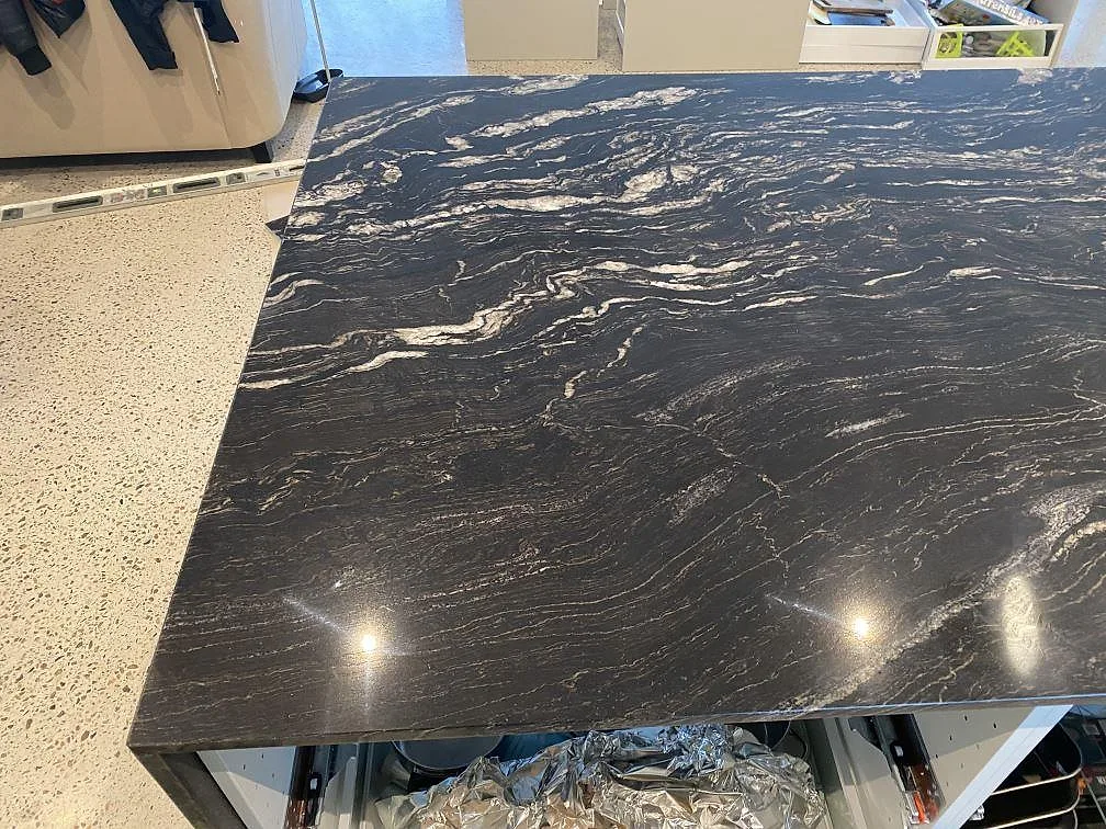 Polerad bänkskiva i Cosmic Black-granit ovanifrån, med ljus ådring mot svart botten, i ett kök i Mörarp.