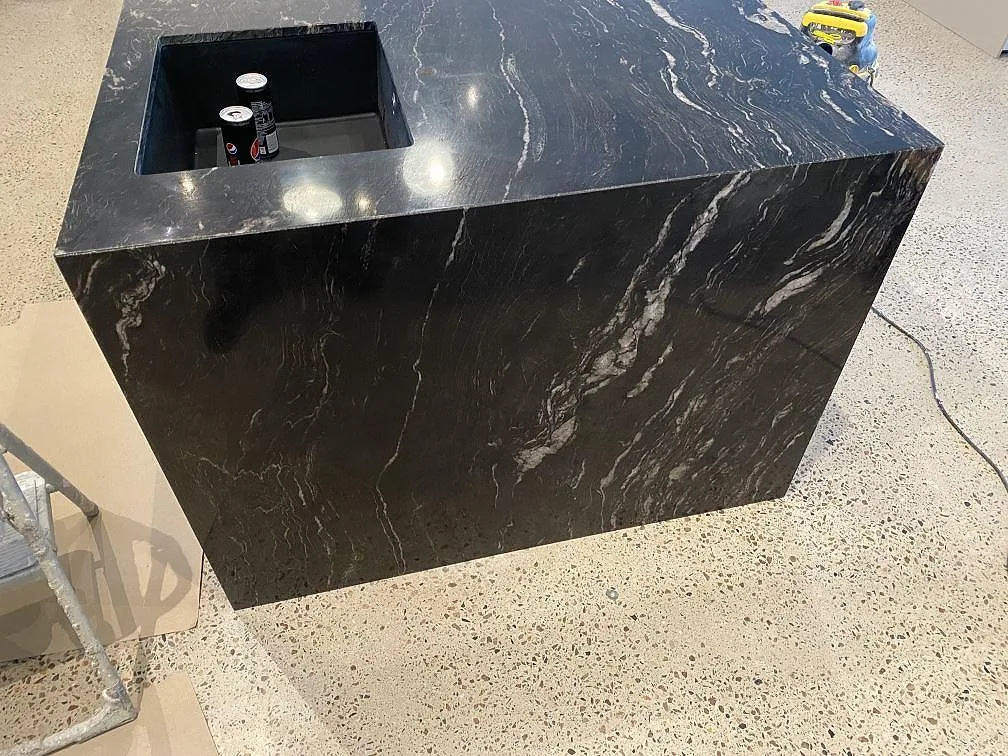 Köksö i Cosmic Black-granit med underlimmad diskho och polerad framkant i ett kök i Mörarp.