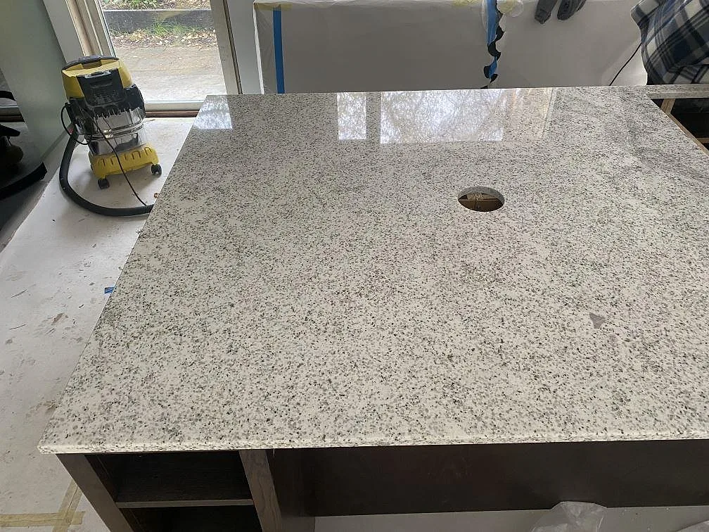 Köksbänkskiva i Cotton White granit med urtag för ho i ett kök vid fönster i Höllviken.