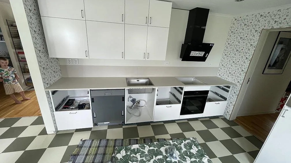 Köksbänkskiva i matt Dekton Aeris, ljus keramik, med rostfri diskho, hällurtag och låg stänkkant i ett kök i Bara.