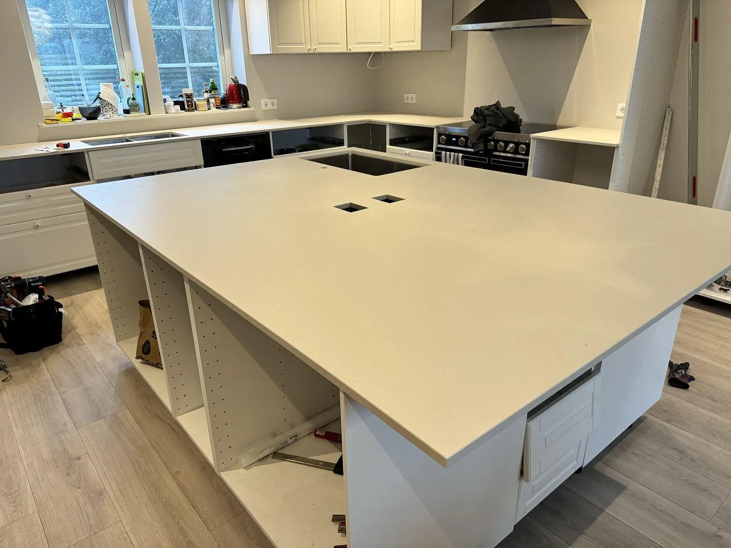 Stor köksö med bänkskiva i matt Dekton Aeris och underlimmad rostfri diskho i ett kök i Höllviken.