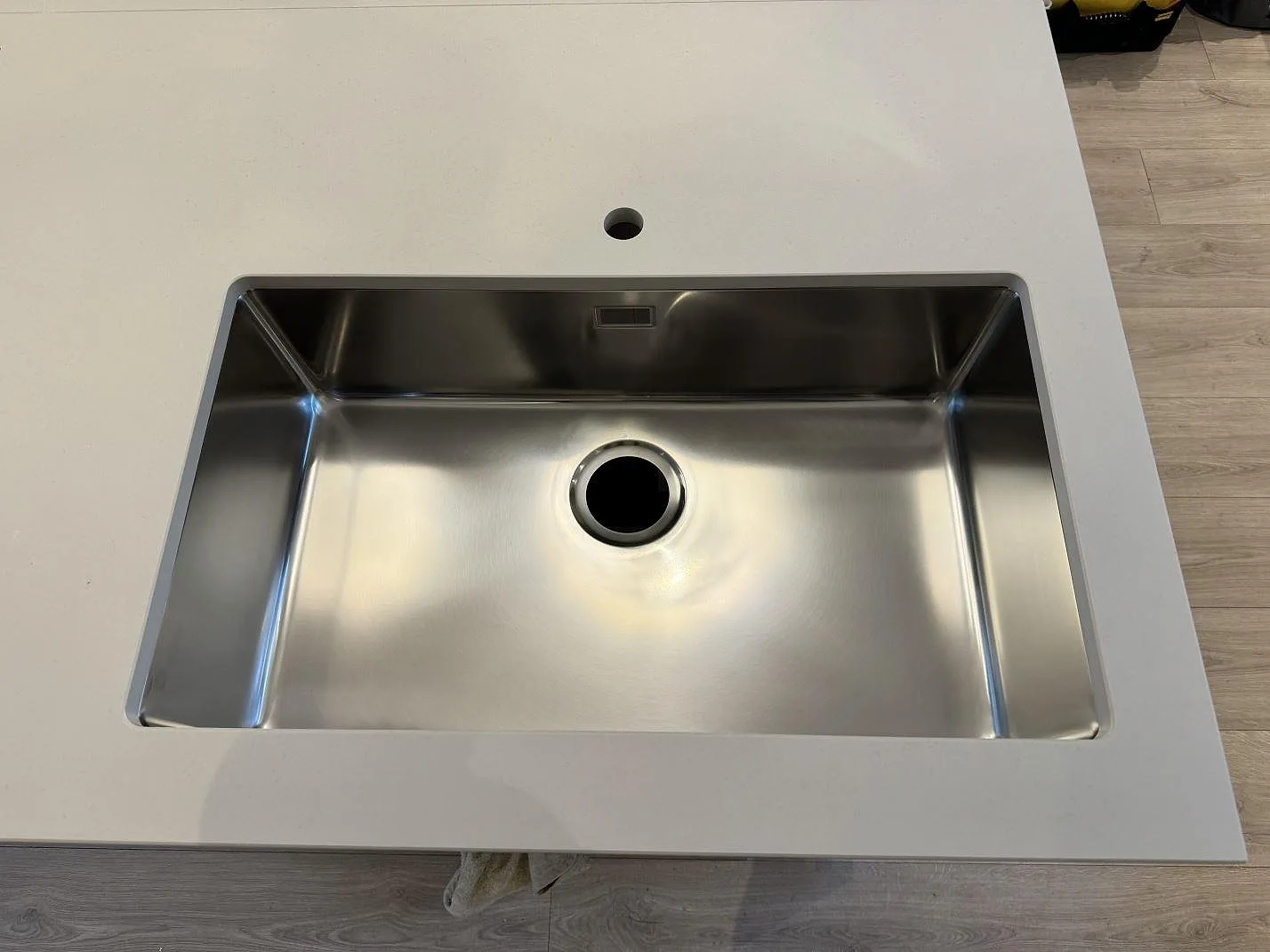 Underlimmad rostfri diskho monterad i matt Dekton Aeris bänkskiva i ett kök i Höllviken.