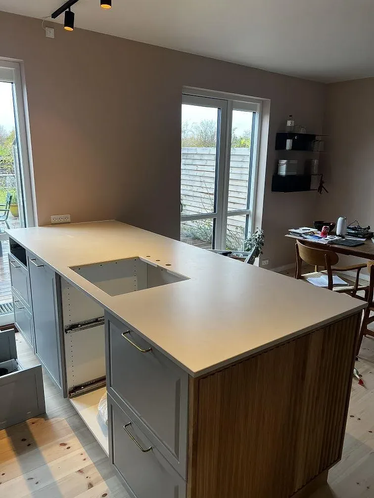 Köksbänkskiva i matt Dekton Aeris keramik, 20 mm, med förberedd öppning och stora fönster i Kgs. Lyngby.