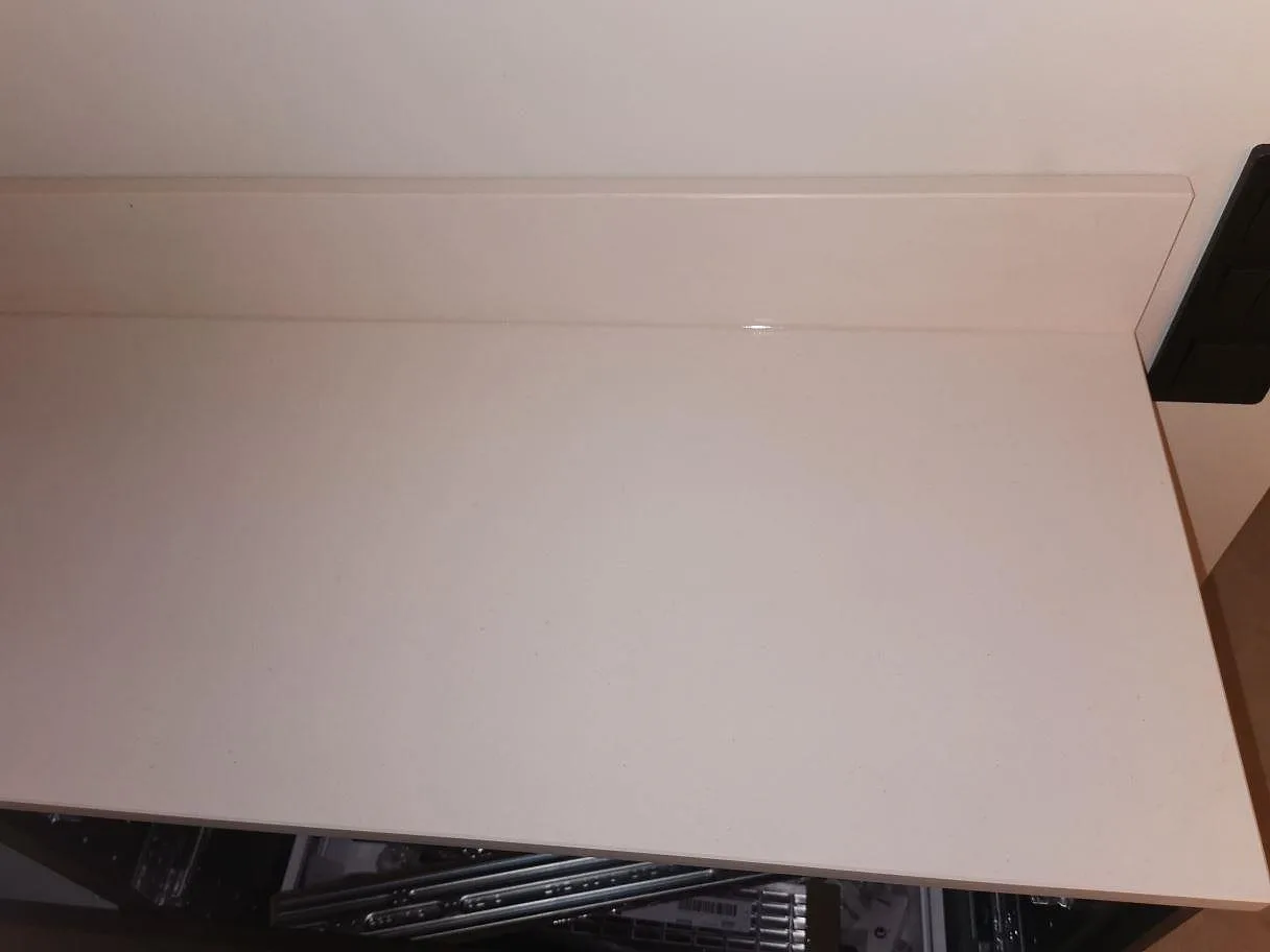 Vit matt Dekton Aeris köksbänkskiva sedd ovanifrån med uppvikt stänkkant i ett kök i Lund.