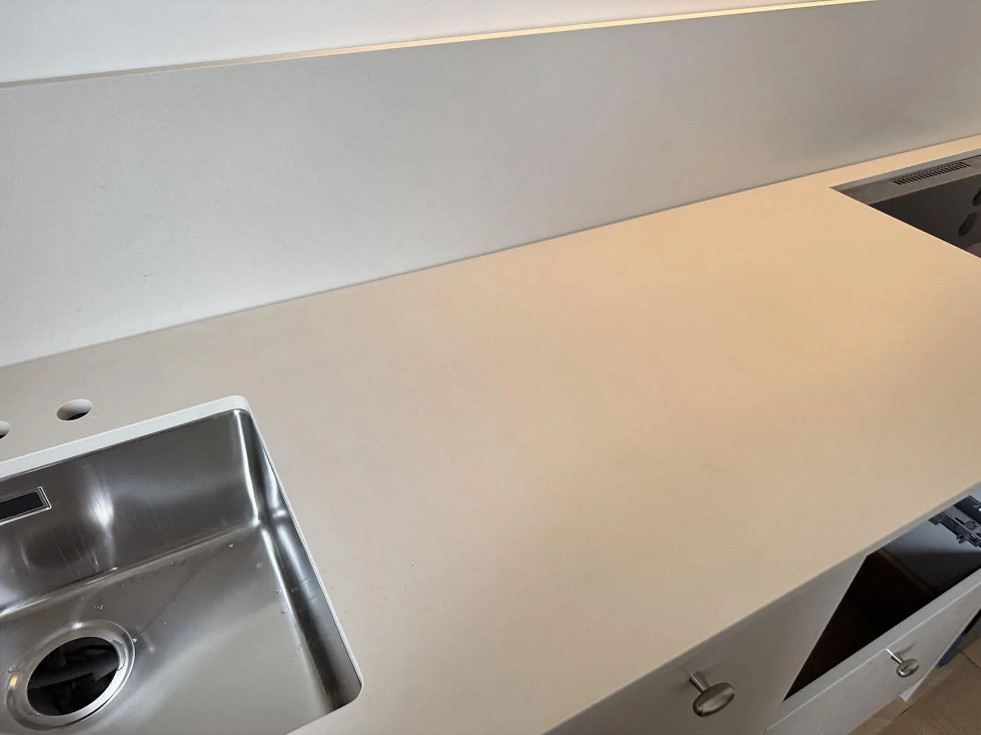 Lång arbetsyta i matt Dekton Aeris keramik med rostfri diskho och stänkkant i ett kök i Malmö.