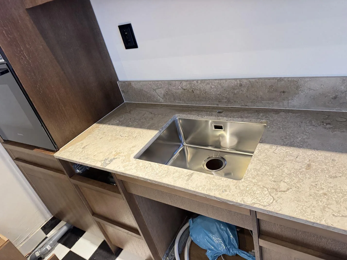 Köksbänkskiva i matt Dekton Aeris keramik med rostfri diskho, uppvikt stänkkant och träinredning i Malmö.