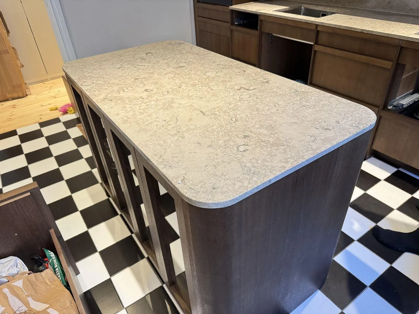 Köksö med bänkskiva i matt Dekton Aeris keramik, rundade hörn och synlig stenyta i ett kök i Malmö.