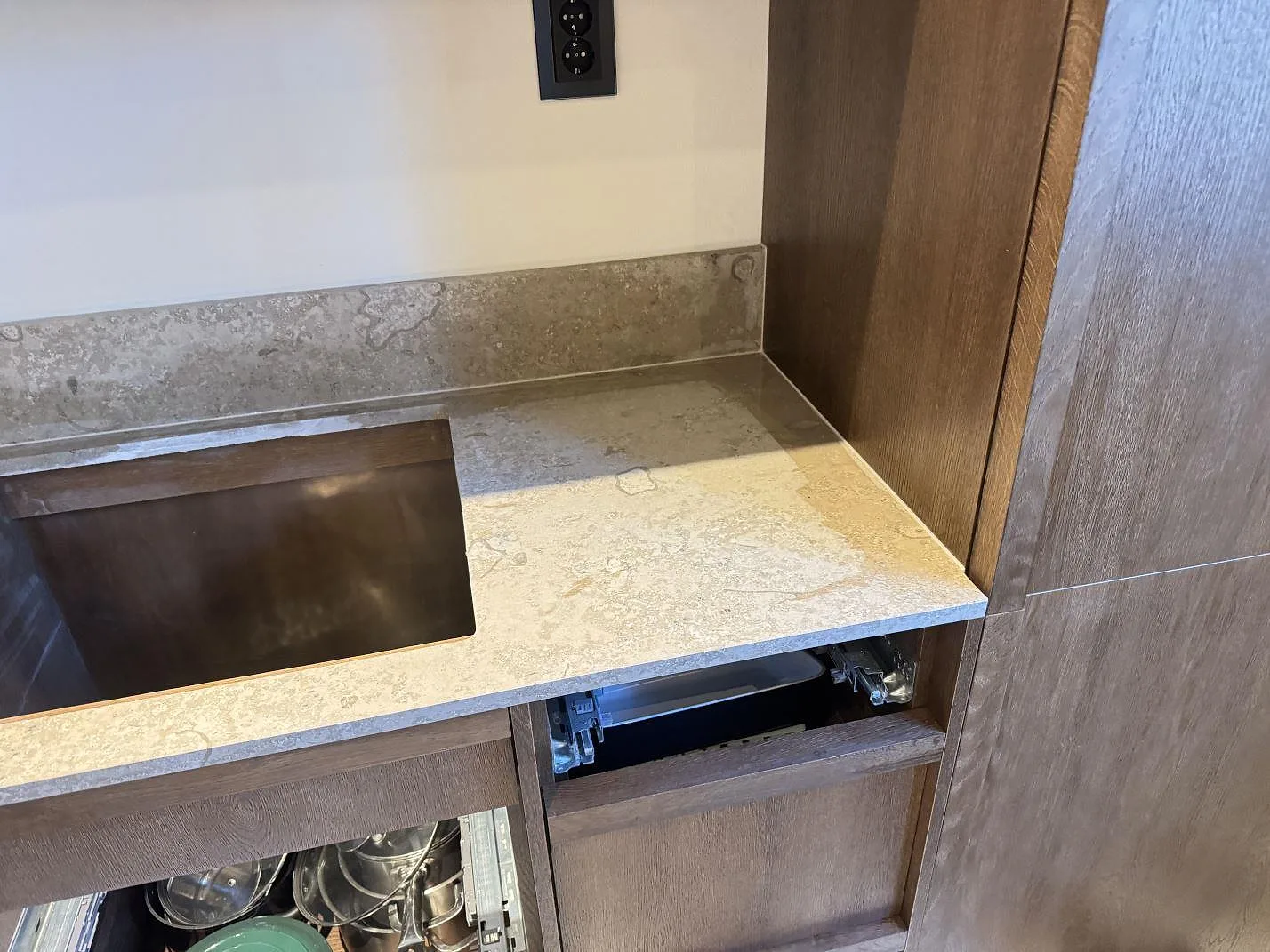 Hörn av köksbänkskiva i matt Dekton Aeris keramik med uppvikt stänkkant och träskåp i Malmö.