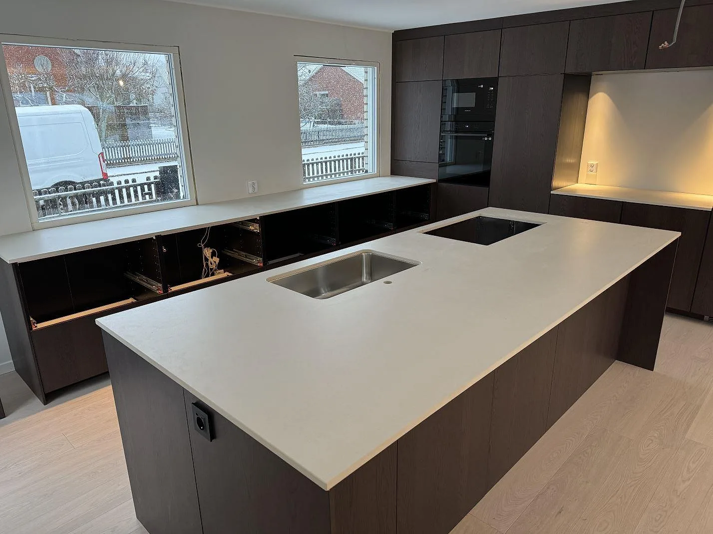 Köksbänkskiva i matt Dekton Aeris på stor köksö med underlimmad rostfri diskho och hällurtag i Mariestad.