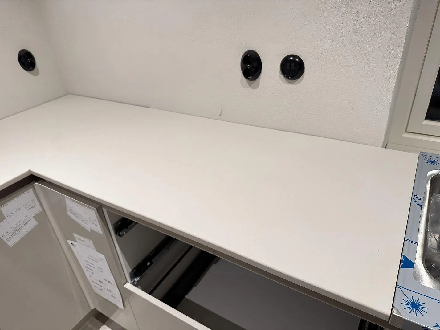 Rak köksbänkskiva i matt Dekton Aeris keramik vid vägguttag och diskho med skyddsfilm i Trelleborg.