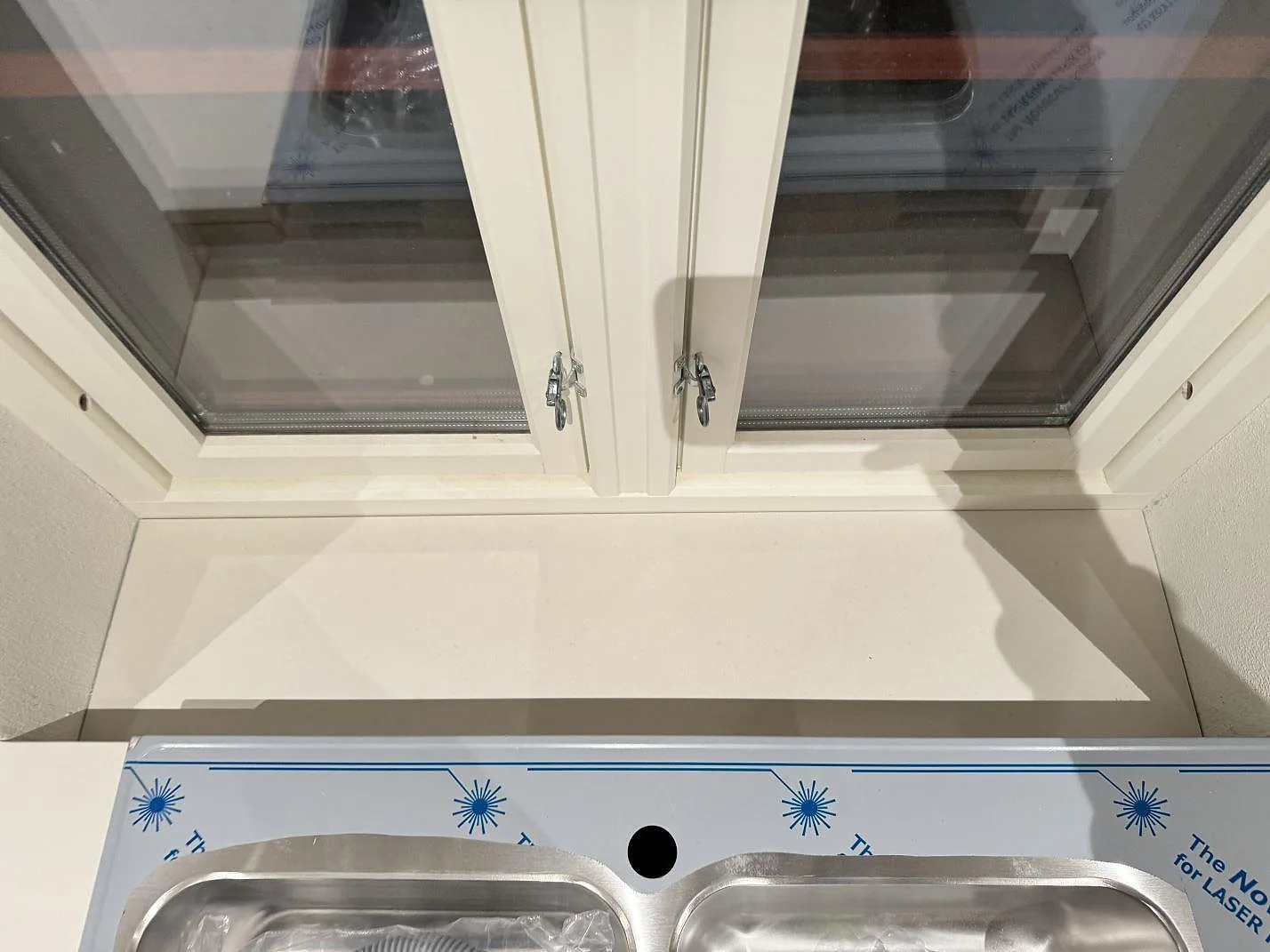 Skiva vid fönster och diskho intill köksbänkskiva i matt Dekton Aeris keramik i Trelleborg.