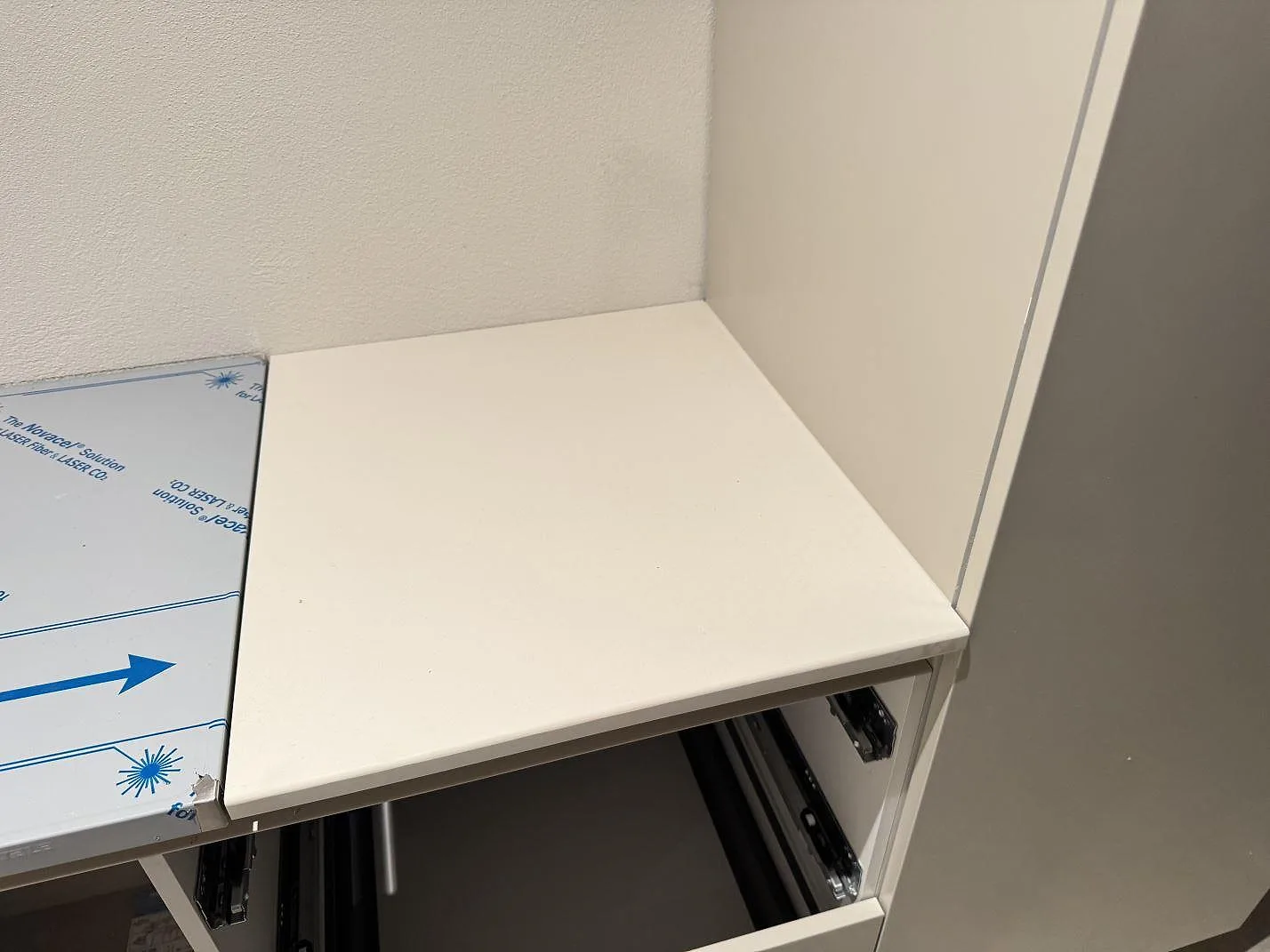 Detalj av ljus köksbänkskiva i matt Dekton Aeris keramik mot vägg och högskåp i Trelleborg.
