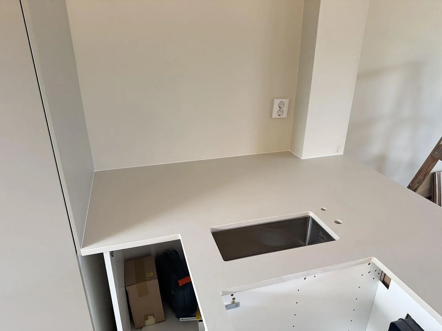 Närbild på matt Dekton Aeris bänkskiva vid diskzon och öppet urtag i ett kök i Ystad.