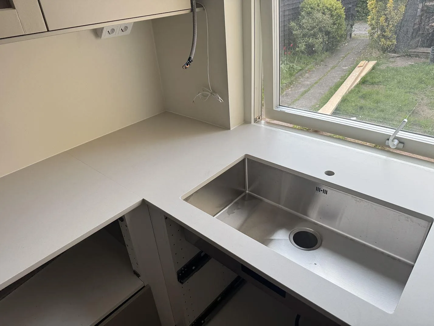 Matt Dekton Aeris keramik runt en synlig diskho vid fönster i köket i Ystad under montering.