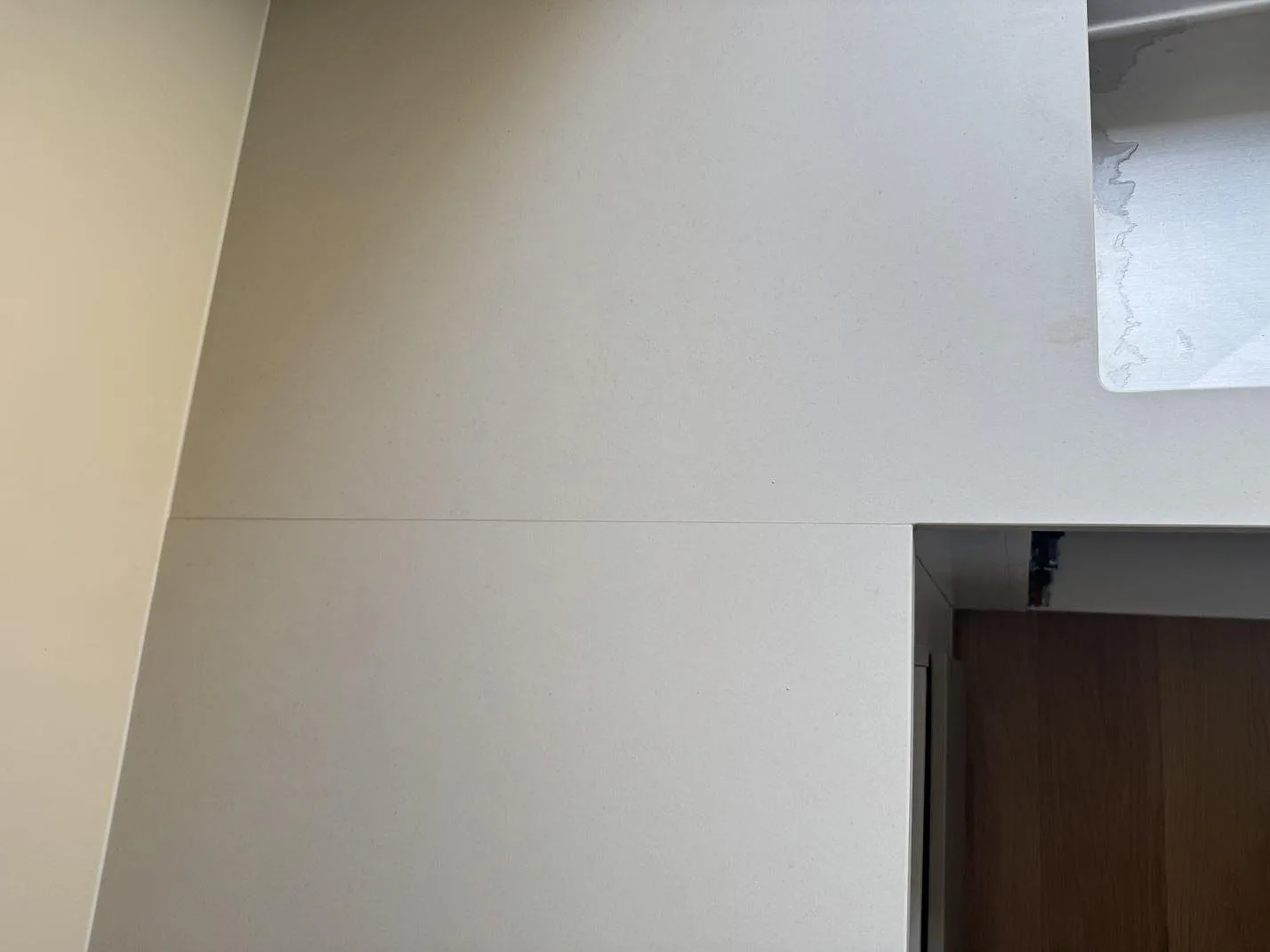 Toppvy av matt Dekton Aeris keramik med ljus yta, skarvlinje och kantdetalj i köket i Ystad.