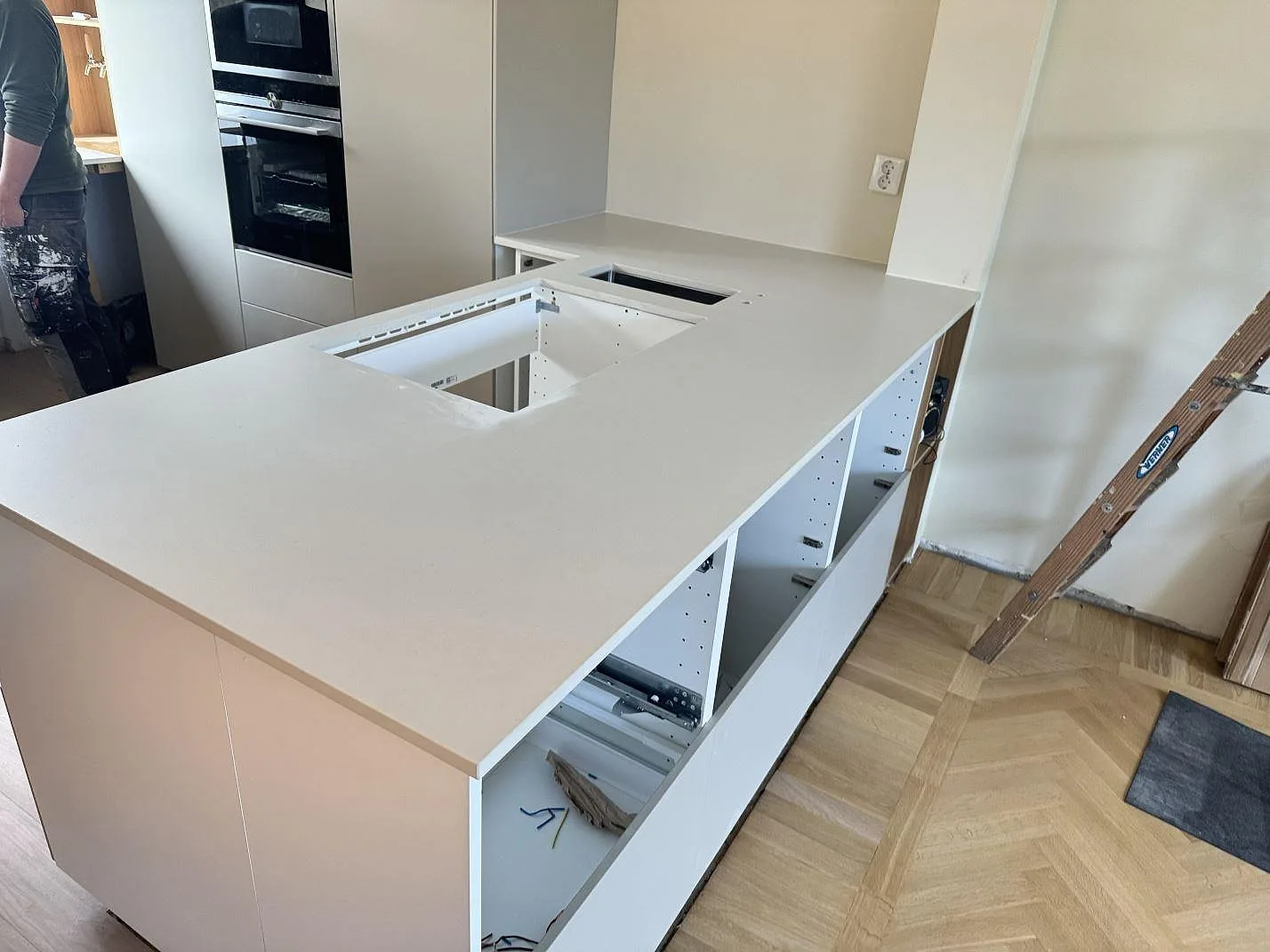 Köksbänkskiva i matt Dekton Aeris keramik med stor arbetsyta och öppet urtag i ett kök i Ystad under montering.