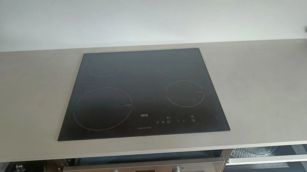 Svart induktionshäll infälld ovanpå en matt Dekton Albarium köksbänkskiva i keramik i Bunkeflostrand.