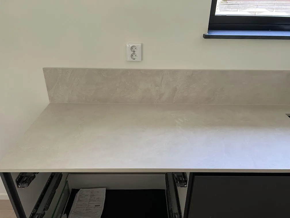 Rak väggbänk i matt Dekton Albarium med 8 mm stänkskydd under fönster i kök i Höllviken.
