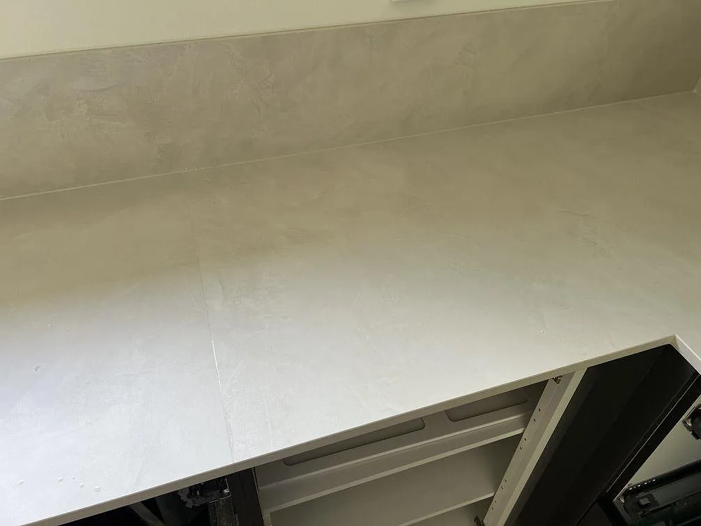 Närbild av ljus matt Dekton Albarium med mjuk stenstruktur och smalt stänkskydd i Höllviken.