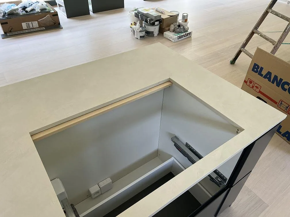 Närbild av stort urtag i köksö med matt Dekton Albarium och ljus stenstruktur i Höllviken.