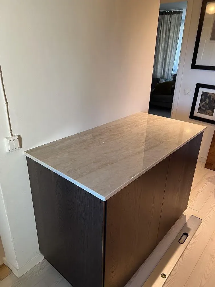 Polerad Dekton Arga keramik som topp på mörk skåpdel, med ljus ådring och blank yta i Älvsjö.