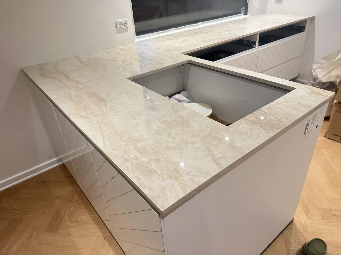 Köksbänkskiva i polerad Dekton Arga, 20 mm keramik, med L-formad arbetsyta och stort öppet urtag i ett kök under montering i Albertslund.