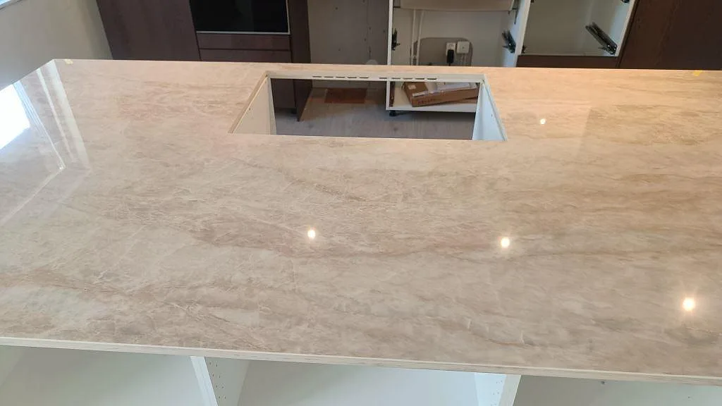 Köksö i Dekton Arga keramik med stort urtag, blank stenbild och öppna skåpstommar under montering i Alvesta.