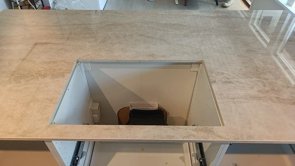 Detalj av urtag och framkant på polerad Dekton Arga köksbänkskiva med ljus marmorering i Alvesta.