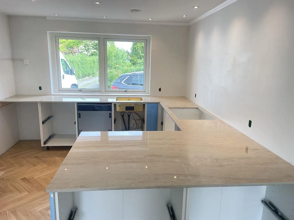 Köksbänkskiva i polerad Dekton Arga keramik med stor halvö och L-formad arbetsyta i ett kök i Bagsværd.
