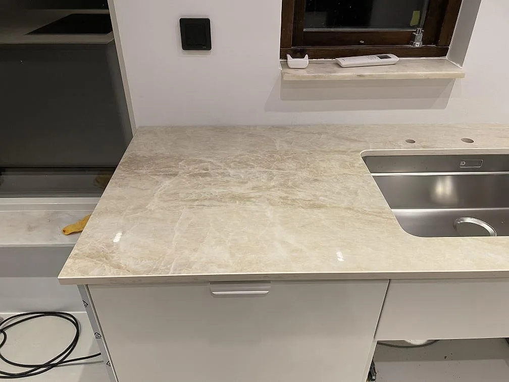 Diskhosida i polerad Dekton Arga med rostfri ho och fönsterparti i Bunkeflostrand.