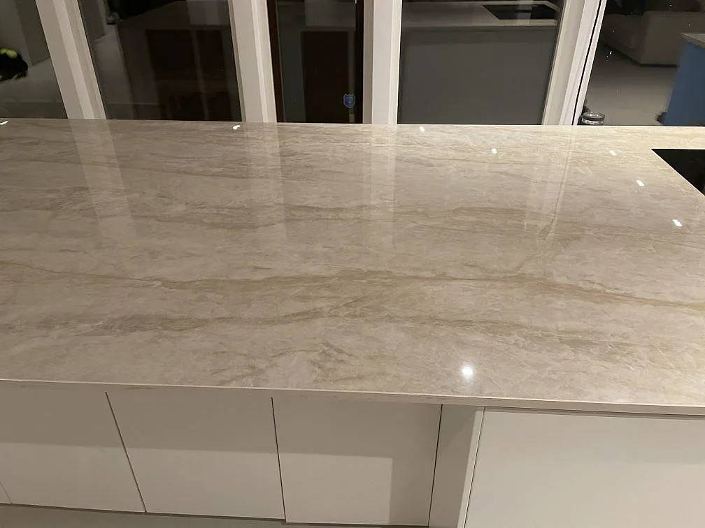 Närbild på blankpolerad Dekton Arga som köksö med beigegrå ådring i Bunkeflostrand.