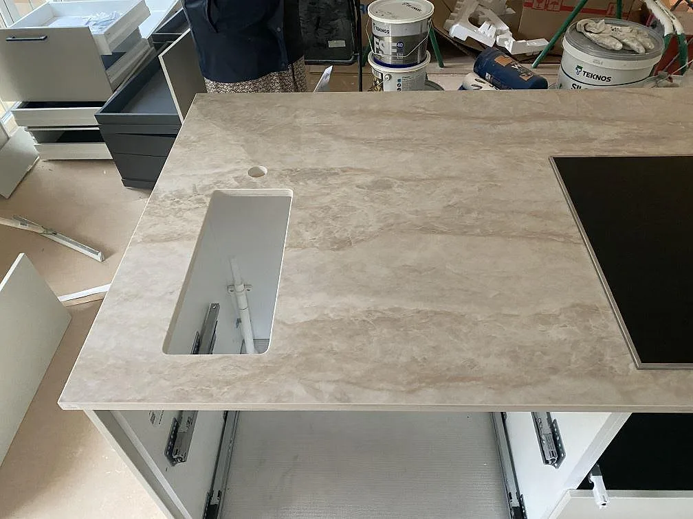 Köksö i Dekton Arga med urtag för diskho och häll, polerad keramikyta, i ett kök i Fjärås.