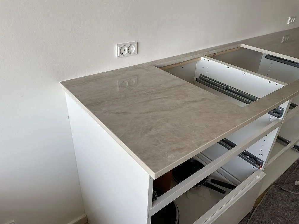 Hälluttag i polerad Dekton Arga keramik med beige ådring på en köksbänkskiva i Frederiksberg.