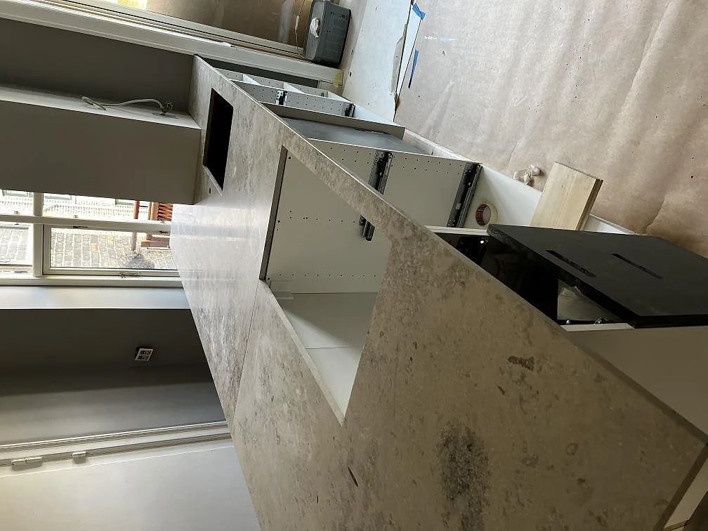 Närbild på den ljusgrå ytan och ådringen i Dekton Arga på en köksö i Frederiksberg.
