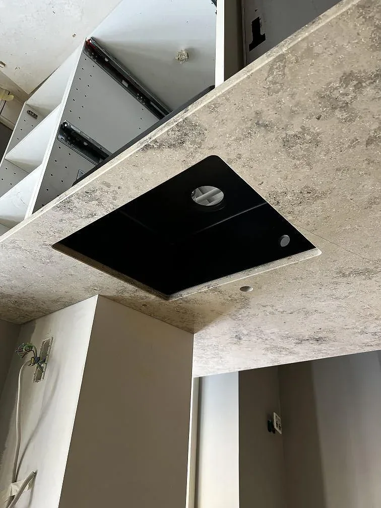 Köksö i Dekton Arga med svart diskho och marmorlik ådring, fotograferad under montering i Frederiksberg.