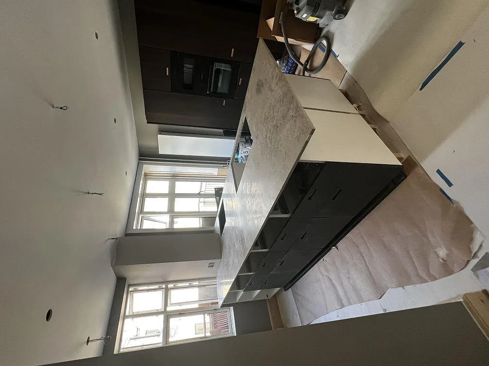 Detalj av stänkkant och hörn i polerad Dekton Arga i ett kök under installation i Frederiksberg.