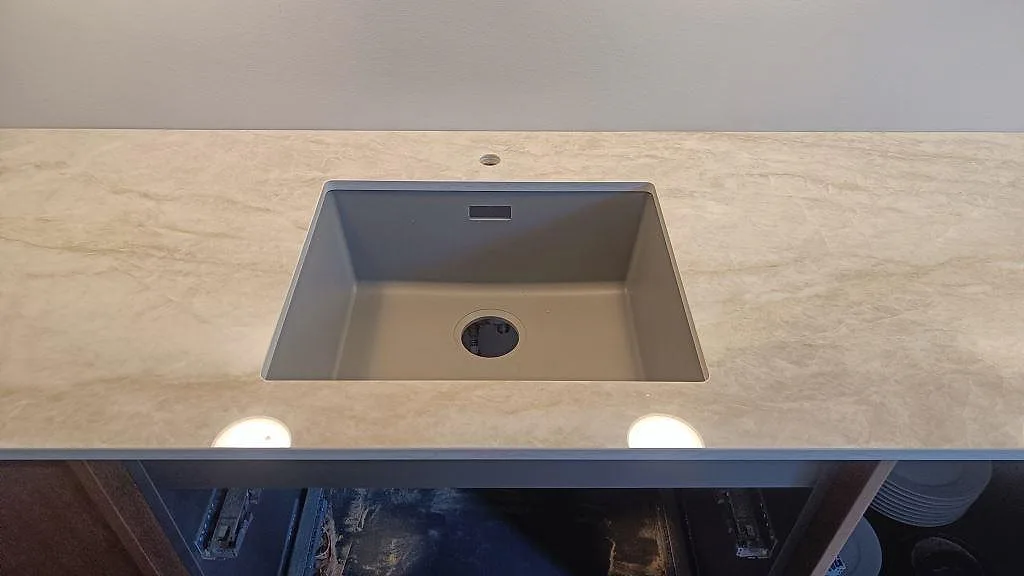 Ovanvy av polerad Dekton Arga köksbänkskiva med svart häll och varm gråbeige struktur i Frederiksberg.