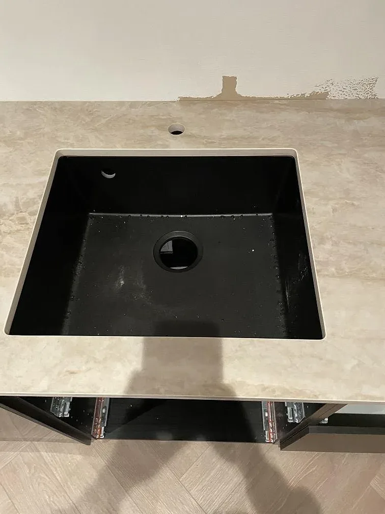 Svart underlimmad diskho i bänkskiva av Dekton Arga keramik i ett kök i Frillesås.