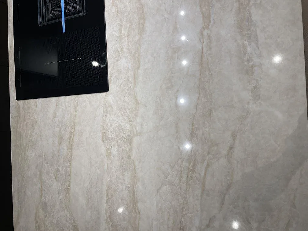 Detalj av infälld induktionshäll i polerad Dekton Arga köksbänkskiva med mjuk grå ådring i ett kök i Frillesås.