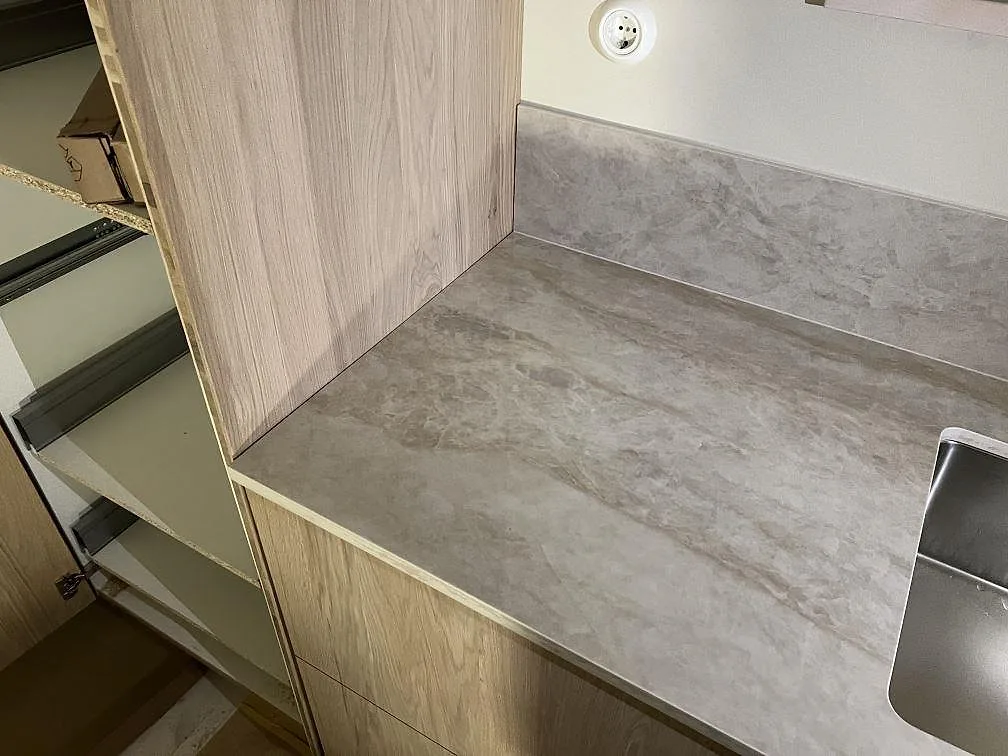 Dekton Arga köksbänkskiva i polerad keramik vid träinredning och rostfri diskho i Gemla.