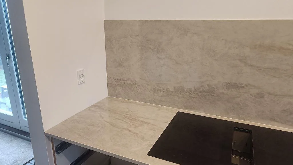 Köksbänkskiva i Dekton Arga vid induktionshäll och stänkskydd, monterad längs väggen i Glostrup.