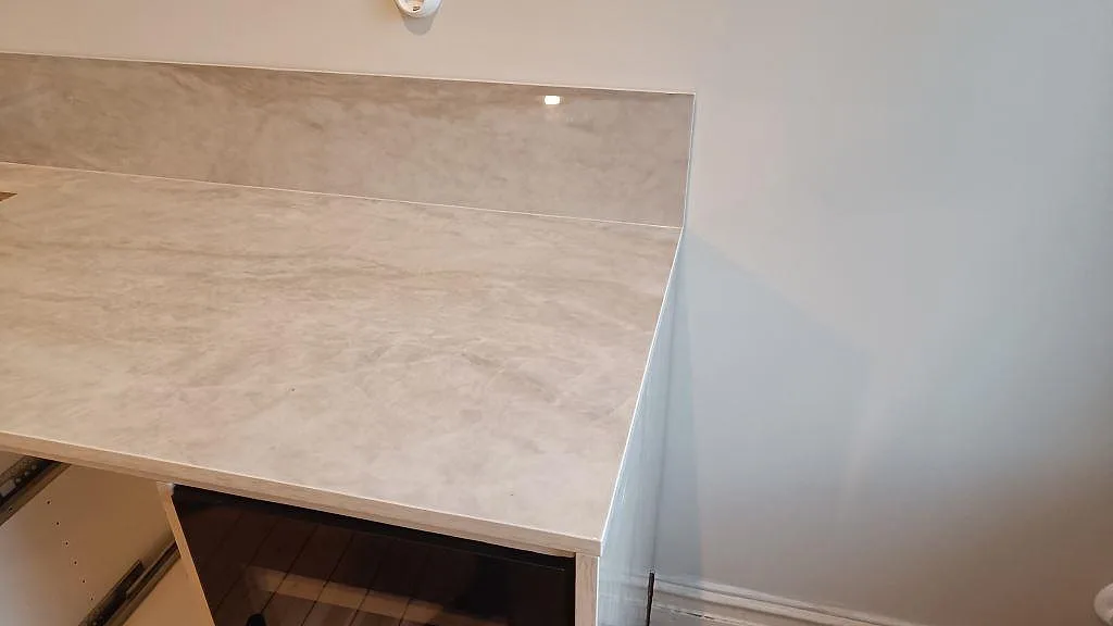Höger avslutning av köksbänkskiva i polerad Dekton Arga med matchande stänkskydd i Göteborg.
