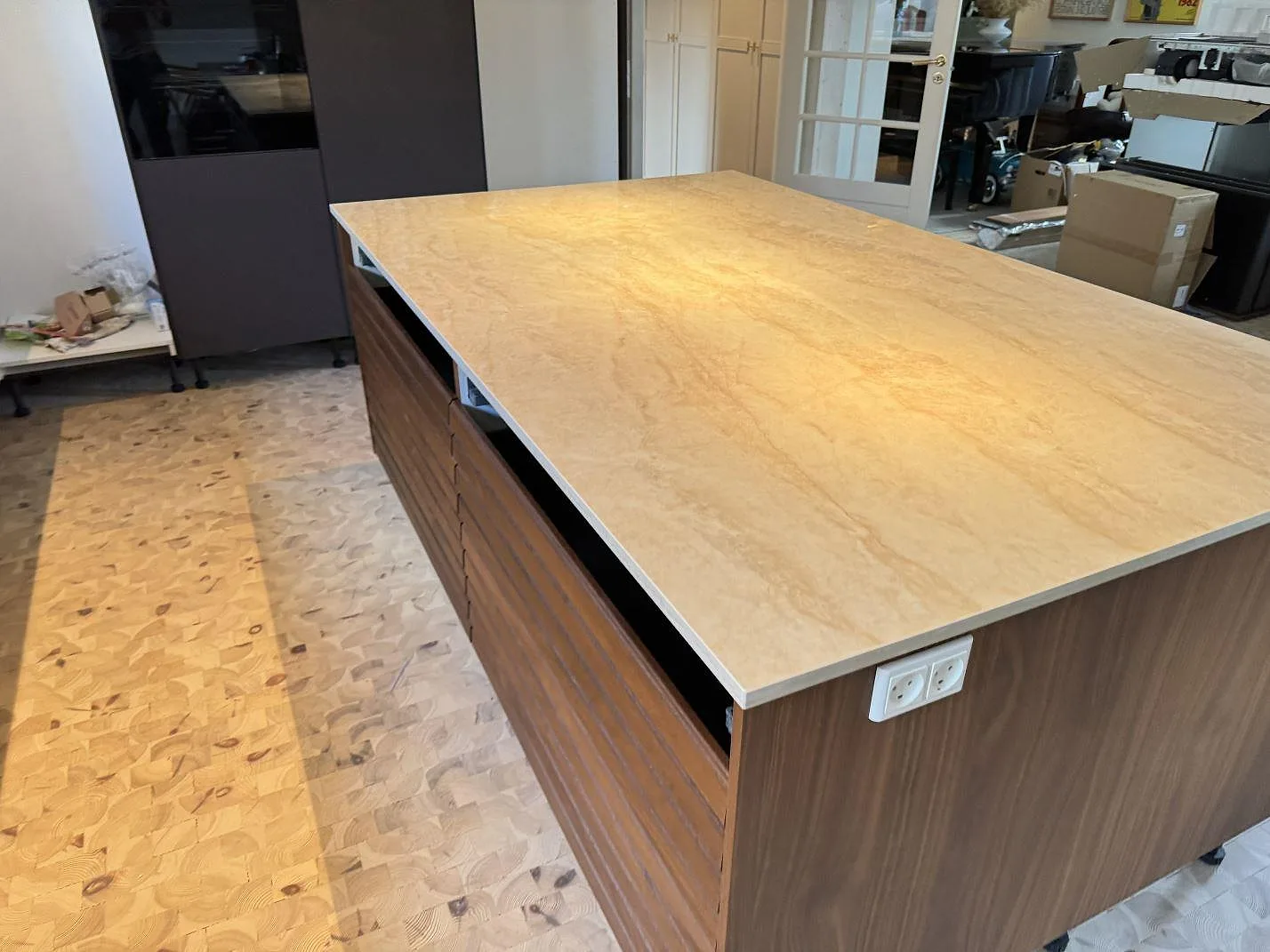 Bred köksyta i polerad Dekton Arga, cremebeige keramik med varm ådring, på en köksdel i Greve.