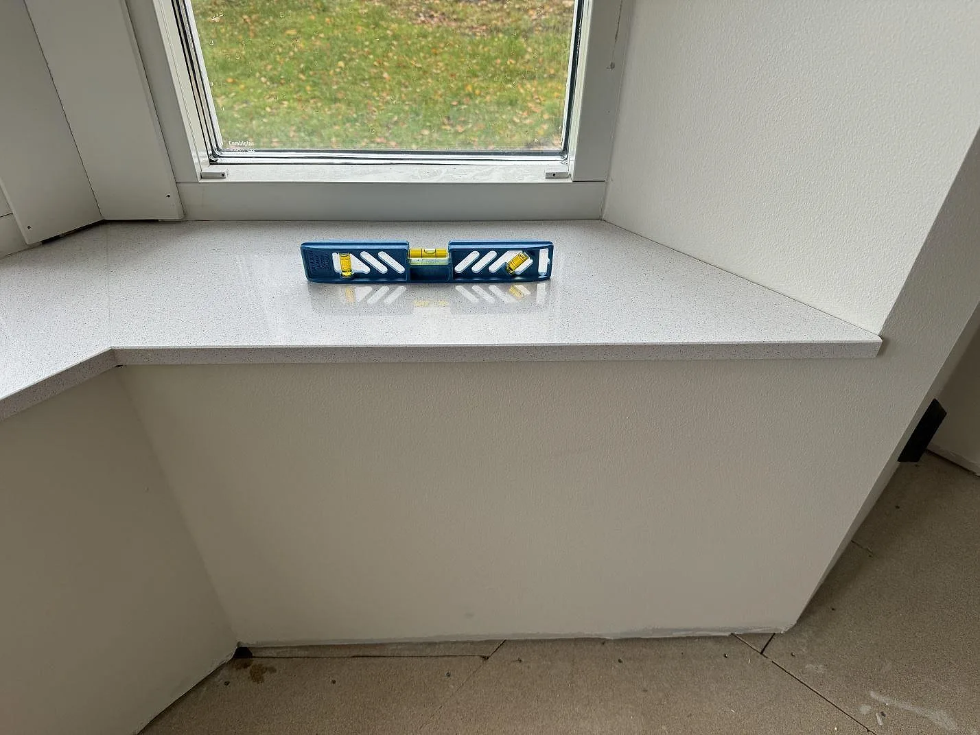 Fönsterbänk i polerad Dekton Arga med synlig framkant och nivåkontroll i Höllviken.