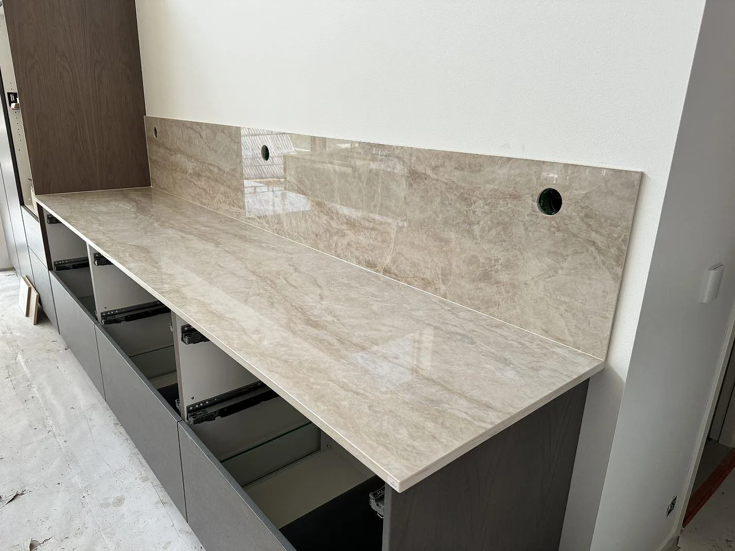 Rak köksbänkskiva i polerad Dekton Arga med 8 mm stänkskydd i samma keramik i ett kök i Höllviken.