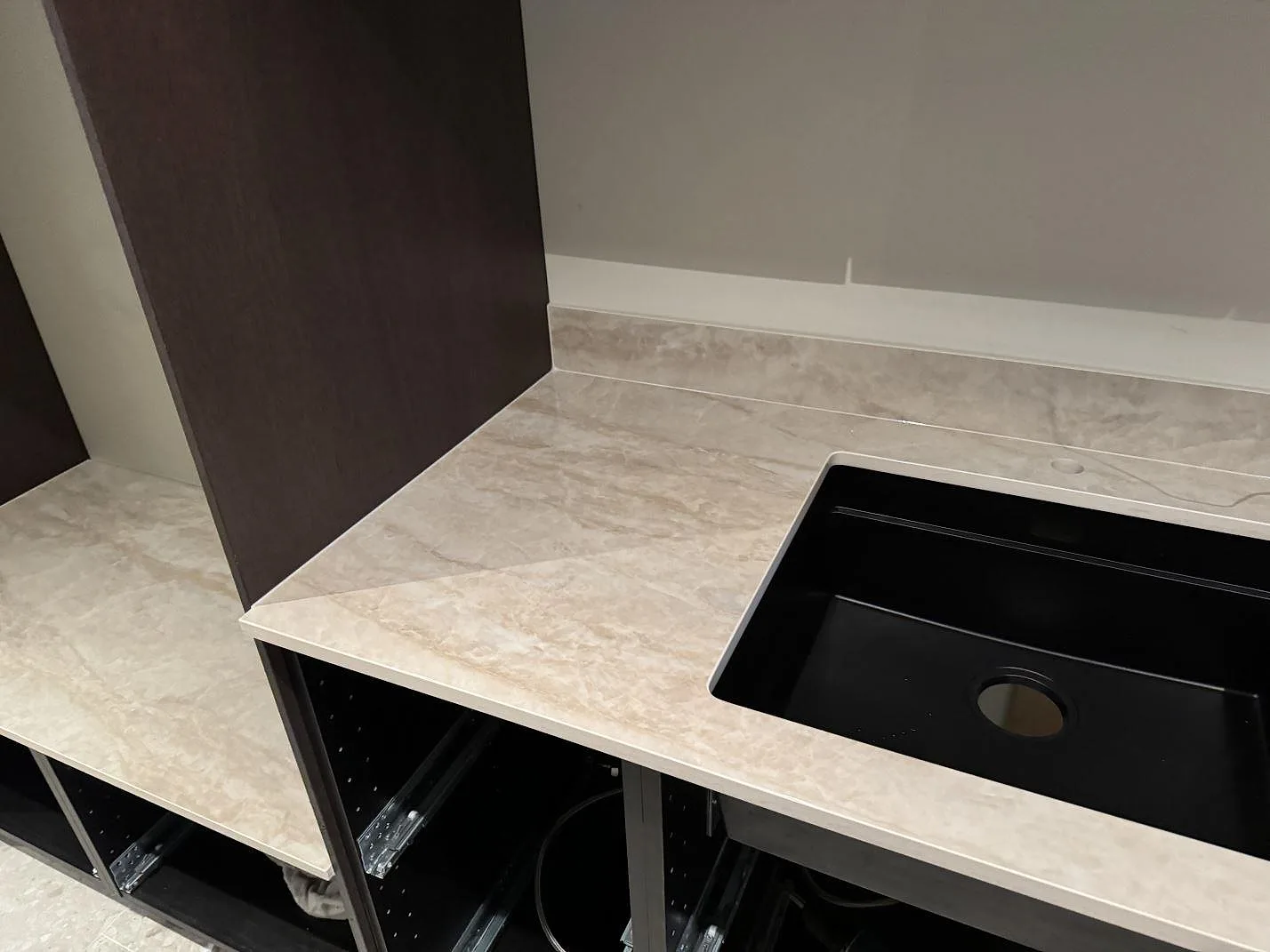 Kök i Höllviken med polerad Dekton Arga som bänkskiva, svart diskho och låg stänkkant i samma keramik.