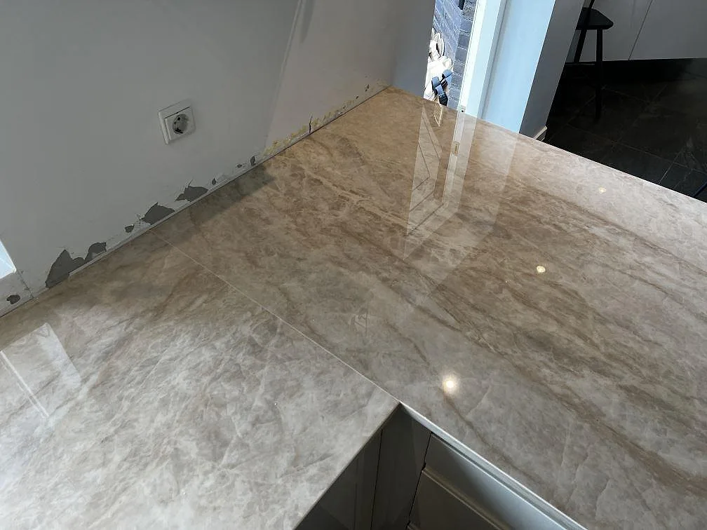 Blank hörnpassning i Dekton Arga keramik med beige och taupe ådring i köket i Hörby.