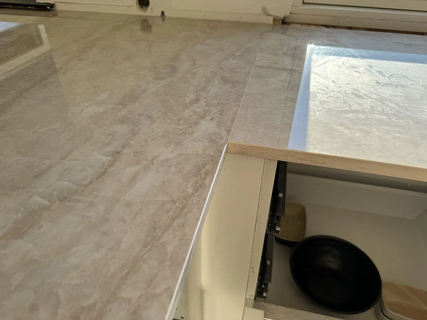 Närbild på skarv och blank yta i polerad Dekton Arga på köksbänkskiva under montering i Hørsholm.