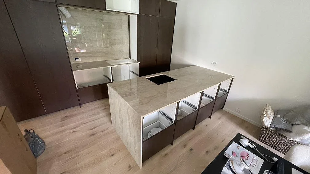 Köksö och köksbänkskiva i polerad Dekton Arga, keramik, med ljus marmorerad yta och diskhoöppning i Holte.